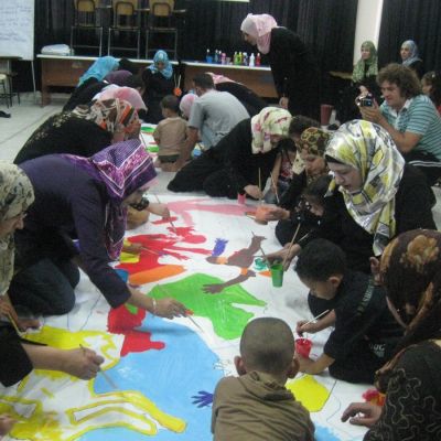 Niños, niñas y madres palestinos/as durante actividades conjuntas de arte-terapia.